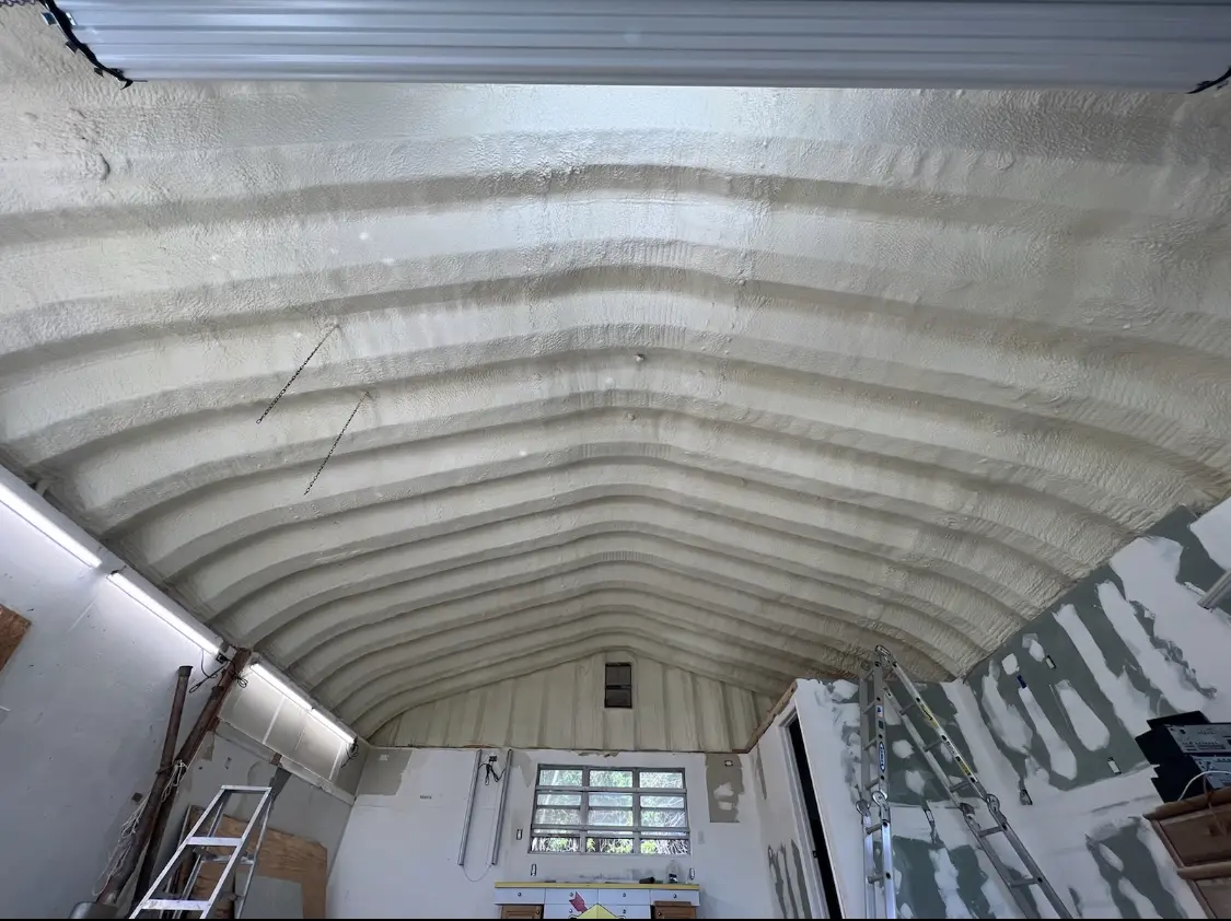Spray polyurethane foam applied to the underside of a metal roof deck in Dyer